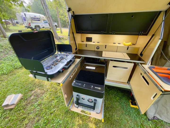 This compact RV rental features a pull-out outdoor kitchen with a stove, fridge, and ample storage, perfect for camping trips.. Nutshell Campers Nutshell Camper 2025
