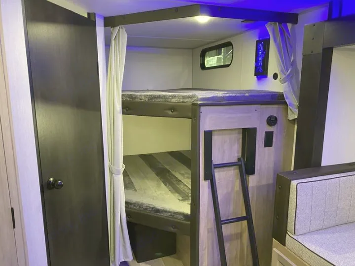 RV rental: Spacious bunk beds within a modern travel trailer, ideal for family adventures on the road.. Grey Wolf 26DBH 2025