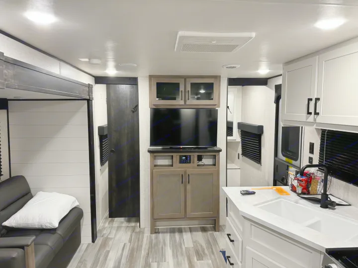Spacious RV rental interior featuring a modern kitchen, living area with couch, and entertainment setup.. Jayco Jay Flight SLX 2024