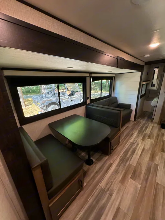 Spacious RV rental interior featuring a cozy dinette, comfortable seating, and scenic views outside the windows.. Jayco Jay Flight SLX 2024