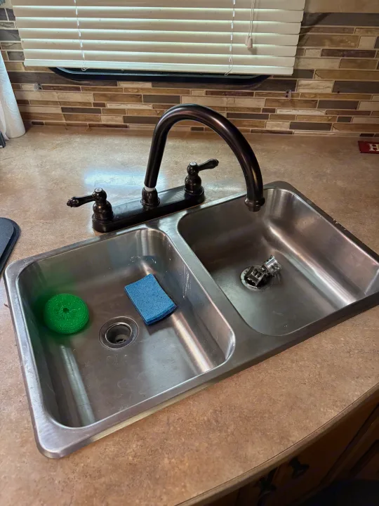This RV rental features a compact kitchen with a double stainless steel sink, dark faucet, tiled backsplash, and window blinds.. Crossroads RV Sunset Trail Super Lite 2016