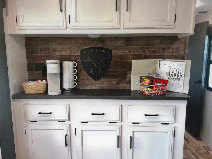 RV rental hospitality area with Keurig coffee maker, stacked mugs, snack basket, and a welcome binder. Enjoy your stay!. SportTrek Venture 2024