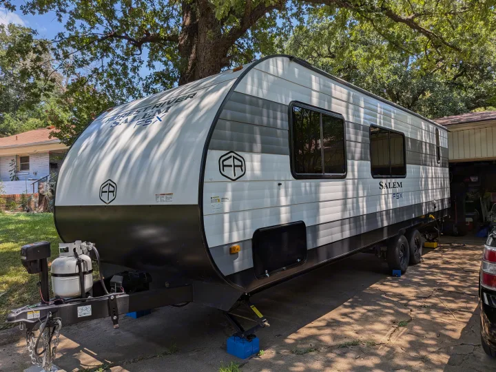 White and gray Forest River Salem FSX travel trailer, ideal for an RV rental, parked on a sunny driveway.. Forest River Salem FSX 266BHLE 2025