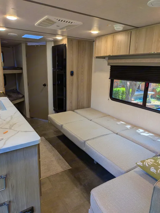 Experience comfort in this modern rv rental. Interior view of the living area, kitchen, refrigerator, and bunk beds.. Forest River Salem FSX 266BHLE 2025