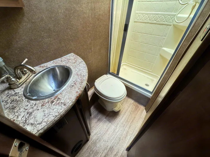 RV rental bathroom with compact sink, toilet, and shower for comfortable travel.. Thor Freedom Elite 2020