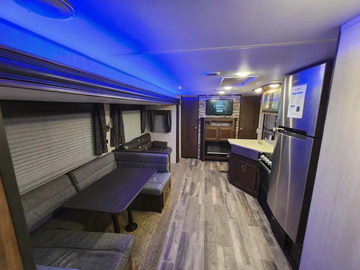 Modern RV rental interior: a bright living area, comfy dining booth, and full kitchen, perfect for travel comfort.. Forest River Cherokee 2019