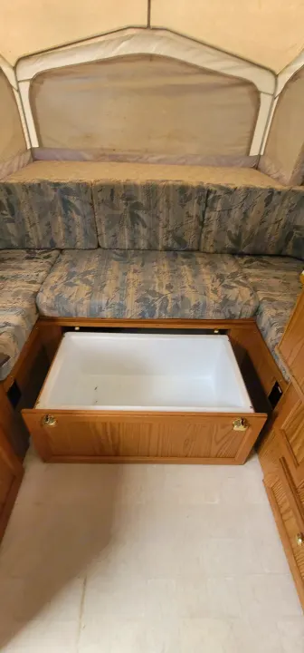 RV rental pop-up camper interior with a bunk bed, patterned seating, and a large pull-out storage tub.. Starcraft Starcraft Popup Trailer 2002