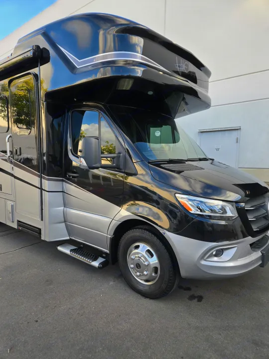 Sleek black and silver Vienna rv rental, a luxury motorhome parked outside. Ready for your next road trip adventure.. Renegade Custom Coaches Vienna 2021