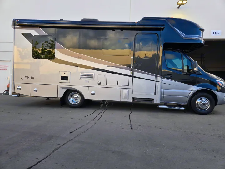 Black and silver Vienna RV rental motorhome, seen parked on asphalt.. Renegade Custom Coaches Vienna 2021