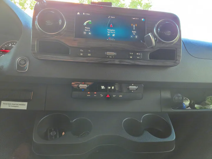 RV rental dashboard: infotainment screen with navigation to Tiger Run Ct, phone, radio. Climate control is. Renegade Custom Coaches Vienna 2021