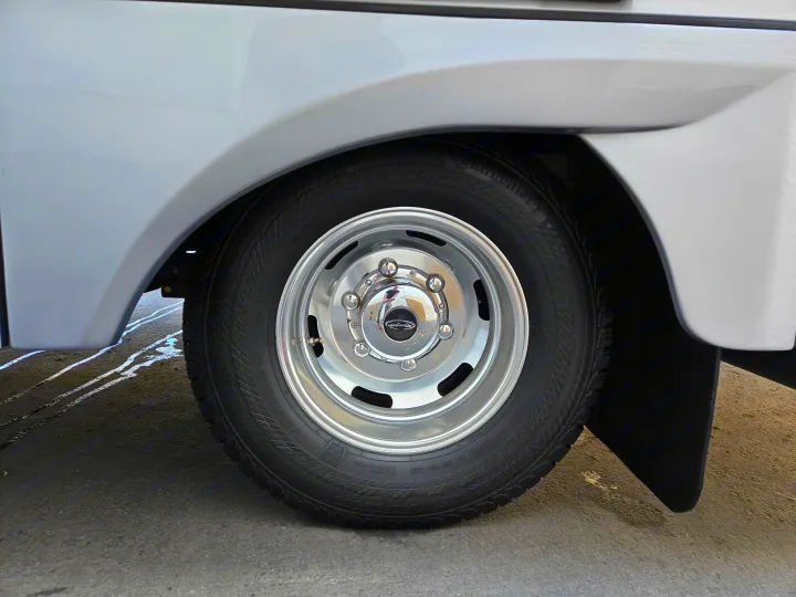 Close-up of a clean Continental VanContact tire and shiny Renegade wheel on an RV rental.. Renegade Custom Coaches Vienna 2021