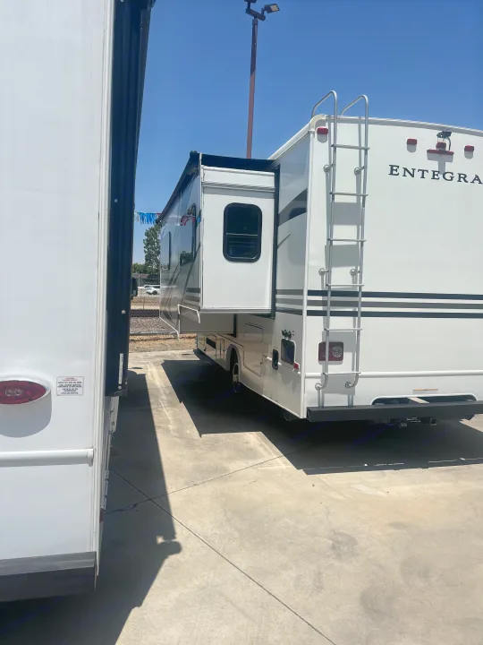 An Entegra RV with an extended slide-out, alongside another, parked on a bright day. Consider an RV rental for your next trip!. Entegra Coach Odyssey 2019
