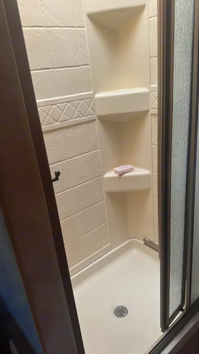 This RV rental features a clean, compact shower with integrated shelves and a soap bar, ideal for road trip comfort.. Thor Chateau 2012