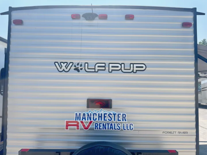 Rear of a silver Wolf Pup RV rental, featuring Manchester RV Rentals LLC branding.. Forest River Cherokee Wolf Pup 2021