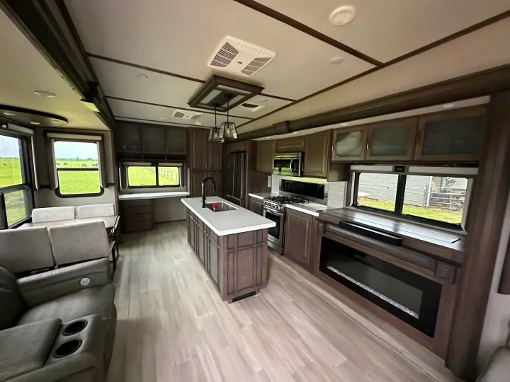 Spacious, modern RV rental interior with full kitchen, living, dining, and scenic views. Ideal for a comfortable travel trailer experience.. Grand Design Solitude 2022