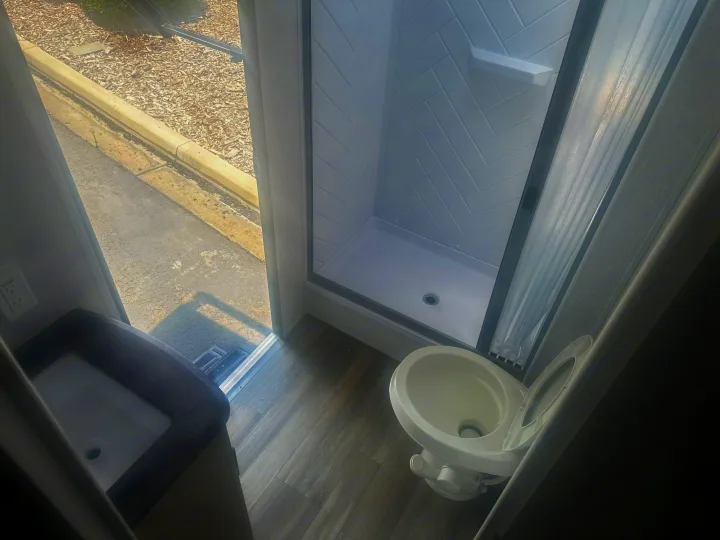 Compact RV rental bathroom: features a toilet, shower, and sink. Perfect for your road trip comfort.. Forest River Evo 2400bhl 2024