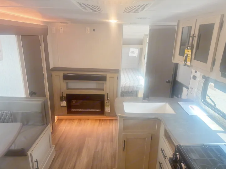 Spacious RV rental interior featuring a cozy dinette, modern kitchen, electric fireplace, and rear bedroom.. Forest River Evo 2400bhl 2024