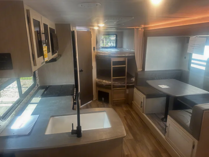 Inside an RV rental: modern kitchen, cozy bunk beds, and a comfortable dining area are clearly visible.. Forest River Evo 2400bhl 2024