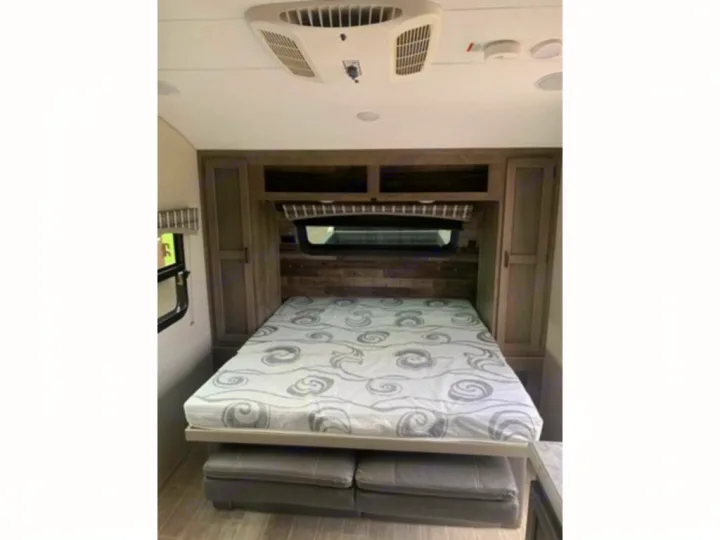 RV rental: This cozy bedroom features a patterned queen bed with under-bed seating, built-in storage, and AC.. Sonic Lite 2021