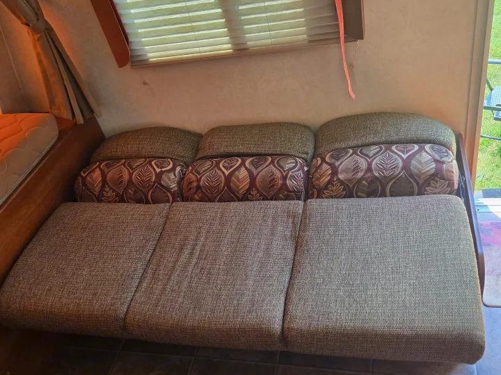 Cozy RV rental interior with sofa/dinette setup and decorative cushions, perfect for relaxing on your trip.. Coachmen Freedom express ltz 2014