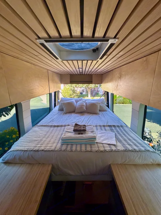 Cozy RV rental interior: a comfy bed, wood ceiling, and scenic window views. Perfect for your next adventure.. Mercedes Sprinter 2007