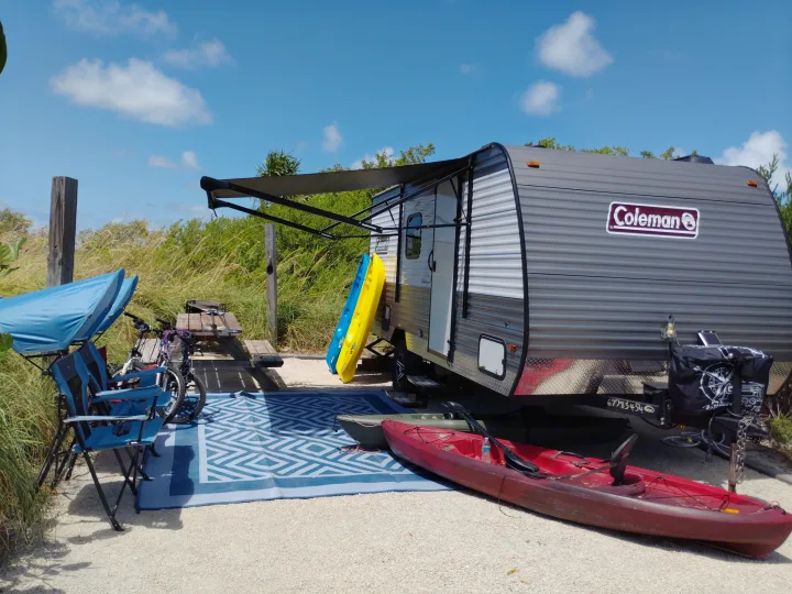 Perfect RV rental setup! Travel trailer with awning, kayaks, bikes, and picnic area for a relaxing outdoor camp.. Dutchmen 17B 2024