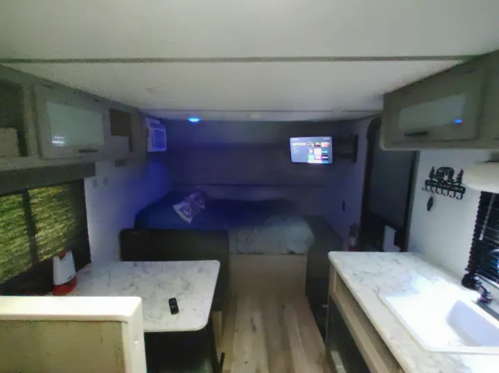 Inside this RV rental: a compact interior with bed, dinette, kitchen, and storage for comfortable travel.. Dutchmen 17B 2024