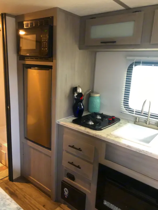 Explore this compact rv rental kitchen: microwave, refrigerator, 2-burner stove, sink, & overhead cabinets.. Coleman Lantern 17R 2024