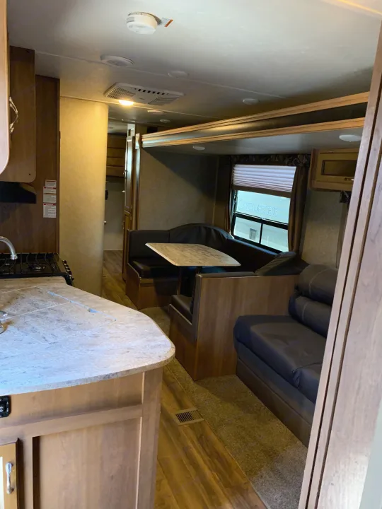 RV rental interior showcasing a compact kitchen, cozy dinette, and comfortable living space with a sofa.. Coachmen Other 2018