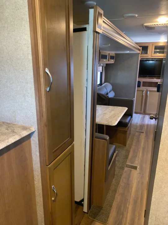 This spacious rv rental interior features a dinette, kitchen counter, and an extended living area via a slide-out.. Coachmen Other 2018
