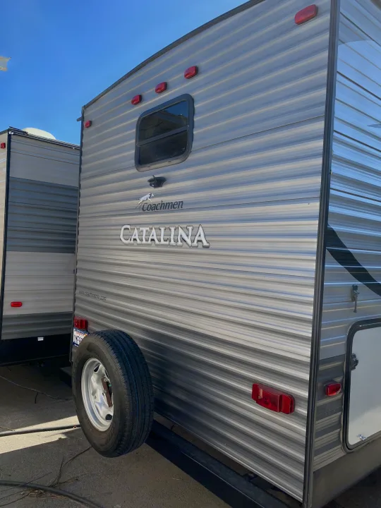 This Coachmen Catalina RV rental, seen from the rear, features grey striped siding, a spare tire, and red lights.. Coachmen Other 2018