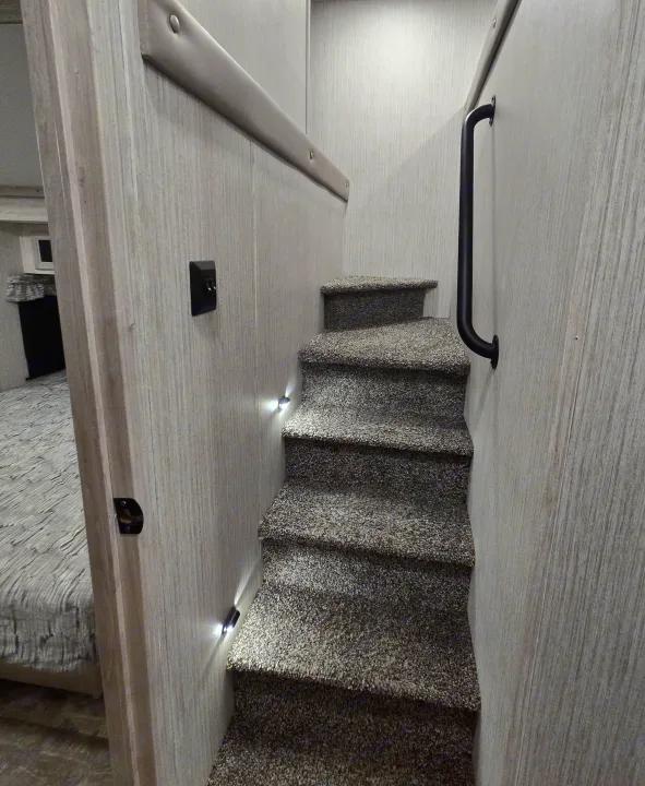 Navigate your RV rental with ease! Carpeted steps, guiding lights, and a sturdy handrail lead to a cozy upper area.. Forest River Sandpiper 2023