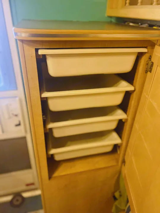 This light wood RV rental cabinet features five pull-out bins, maximizing storage for travel essentials.. Forest River M-17 2005