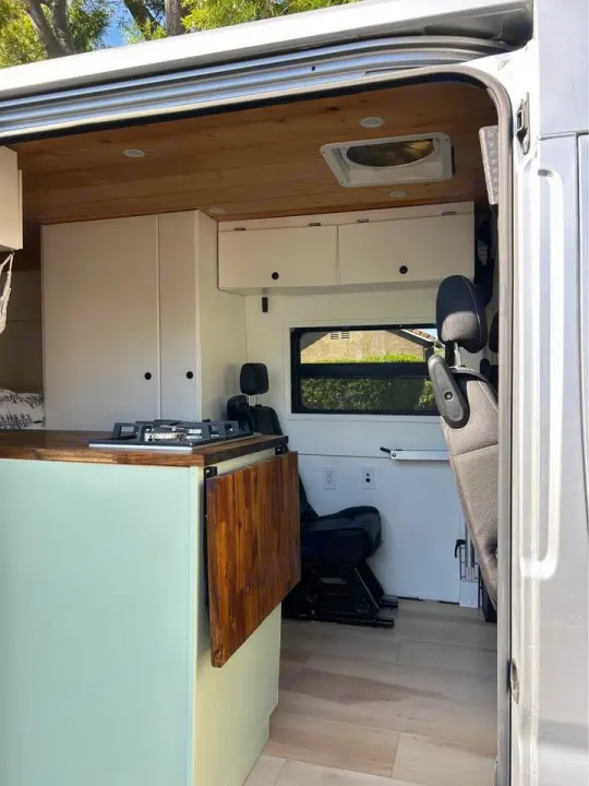 Get ready for adventure in this cozy rv rental van conversion, featuring a compact kitchen, smart storage, and wooden accents.. Dodge Ram ProMaster 2021