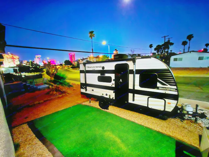 **RV rental** at night with bright Las Vegas city lights and moon.. Grand Design Transcend One 151BH 2025