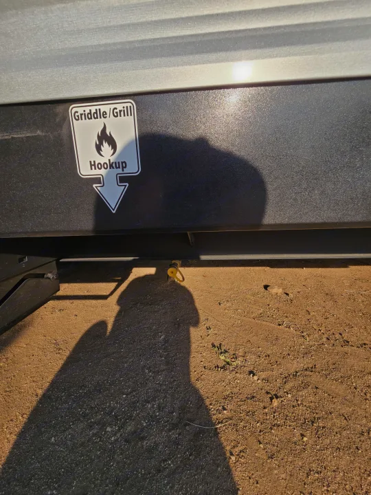 RV rental with a clear "Griddle/Grill Hookup" and gas quick-connect, perfect for outdoor cooking.. Colman 23B 2025
