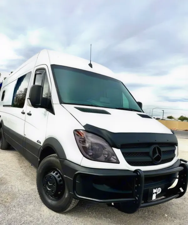 Rugged white Mercedes Sprinter van with black trim & brush guard, perfect for your next RV rental adventure.. Mercedes Sprinter 2012