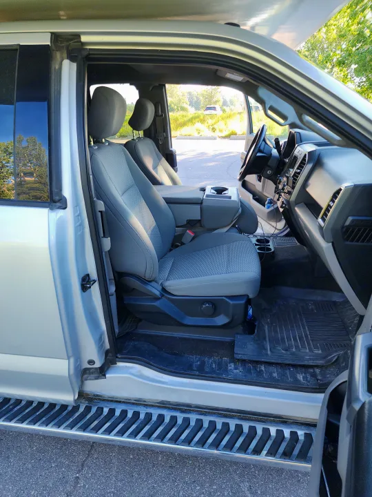 Spacious light-grey truck interior with open door, showing seats, dash, & floor. Ideal for any road trip, even an RV rental adventure.. Ford Ford F150 2017