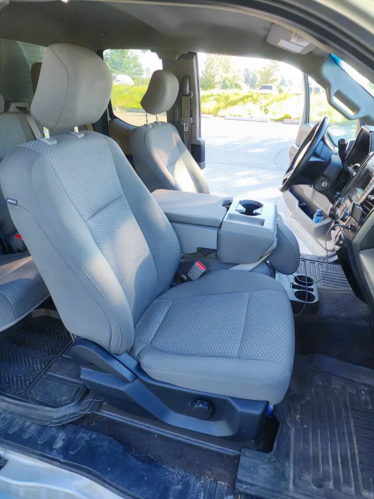 Clean vehicle interior for rv rental. Shows spacious grey fabric seats, console, & floor mats.. Ford Ford F150 2017