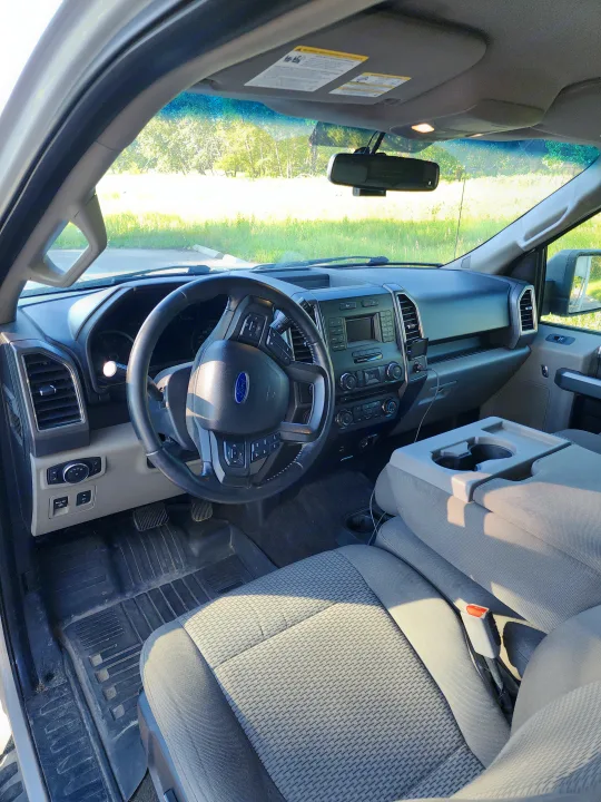 Inside a gray Ford truck: dashboard, steering wheel, & seats visible. Ready for an RV rental adventure.. Ford Ford F150 2017