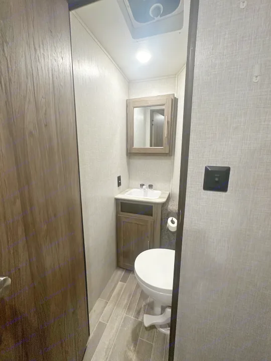 Compact RV rental bathroom featuring a toilet, sink, and mirrored medicine cabinet, designed for efficient travel.. Crossroads RV Zinger 2020