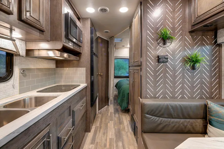 Modern RV rental interior with a fully-equipped kitchen, dinette, and comfortable bedroom, perfect for travel.. Entegra Coach Odyssey SE 2024