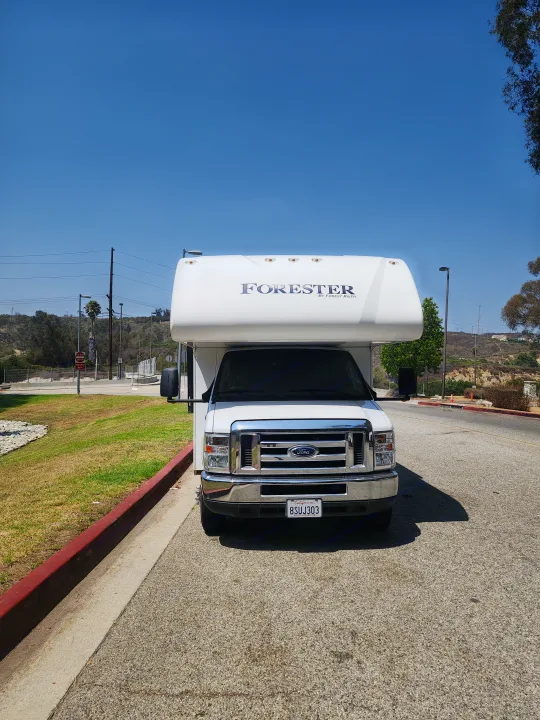 White Ford Forester RV rental parked on a sunny day. This motorhome, California license 8SUJ303, awaits its next adventure.. Forest River Forester 2018