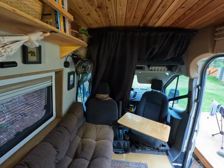 This RV rental offers a compact van conversion with wooden accents, a comfy lounge, and driver's area.. Ford Transit 2017