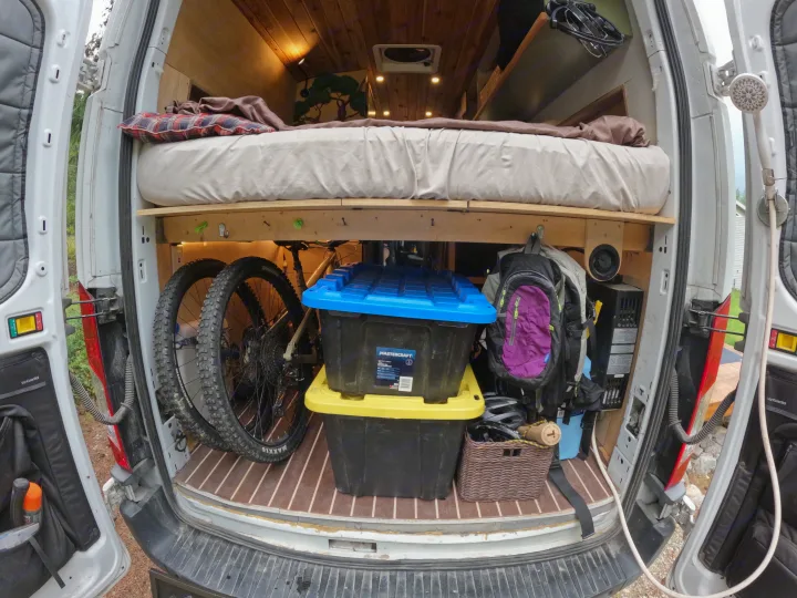 This RV rental shows the clever storage and bed setup in a camper van, perfect for adventures with bikes and outdoor showers.. Ford Transit 2017