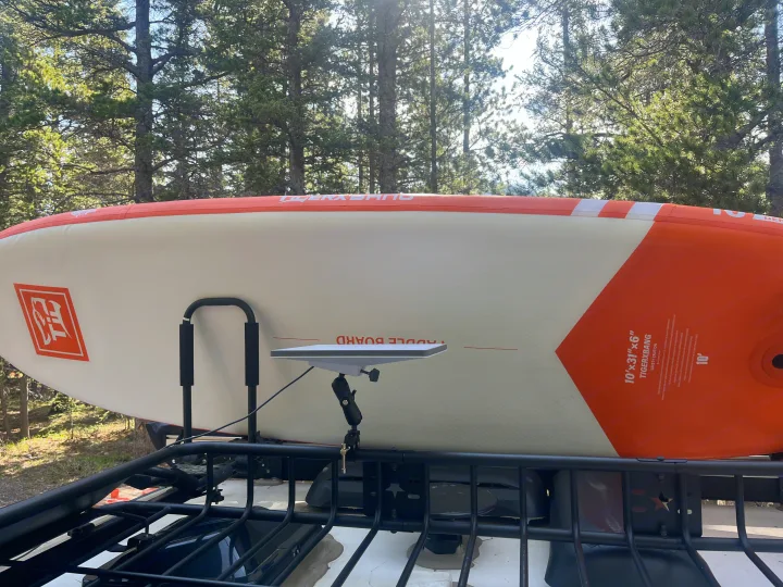 Paddleboard & Starlink mounted on an rv rental roof rack, ready for outdoor adventures amidst pine trees.. Sunset park rv Sunray 109 2025