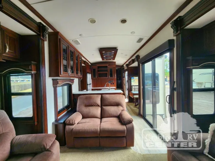 Inside a modern RV rental: a spacious living area with recliners, full kitchen, and large windows offering great views.. Jayco Designer 39RE 2017