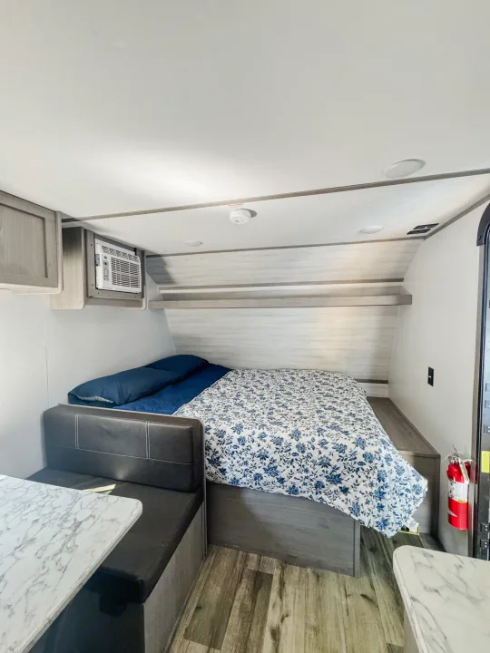This compact RV rental features a comfortable bed, a dinette with a marble table, and built-in AC.. Dutchmen Coleman Lantern LT 2023