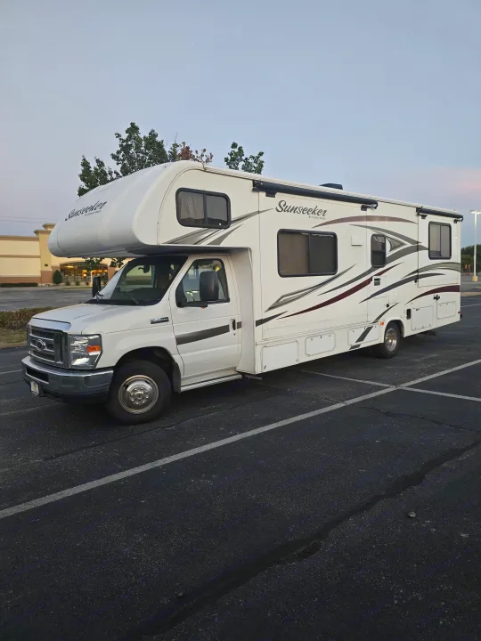 White Ford F-450 Class C RV rental, a Sunseeker model, parked in a lot. Ready for your travel journey.. Forest River Sunseeker 2016