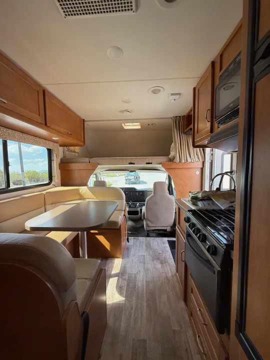 Spacious RV rental interior featuring a cozy dinette, modern kitchen, and driver's cabin, all set for your next adventure.. Winnebago Minnie Winnie 2016